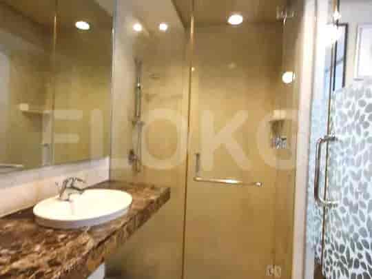 A modern bathroom with a glass-enclosed shower, a marble countertop sink, and a tiled accent wall.