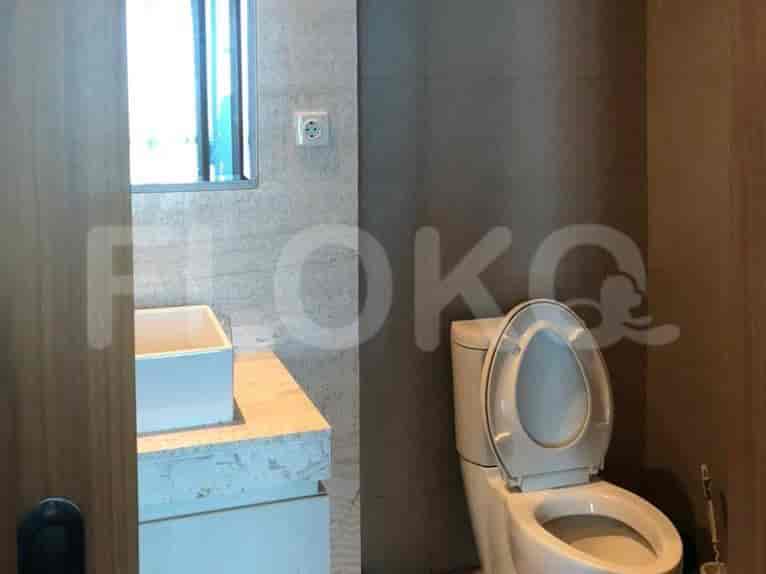 A bathroom with a sink, toilet, and a mirror.