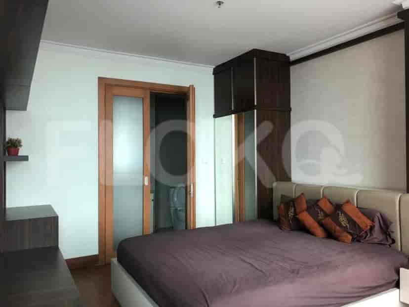 A bedroom with a bed and a bathroom door.