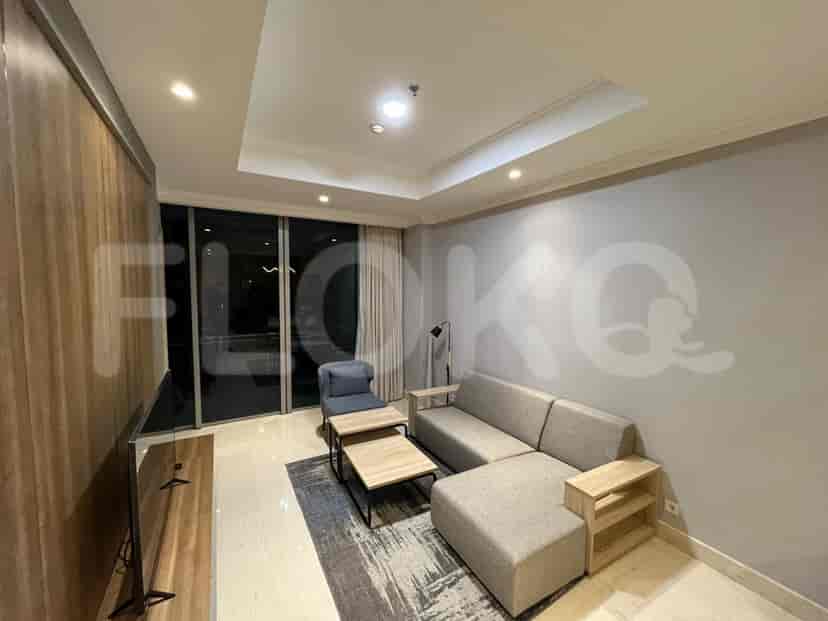 The living room features a grey L-shaped sofa and a large window.