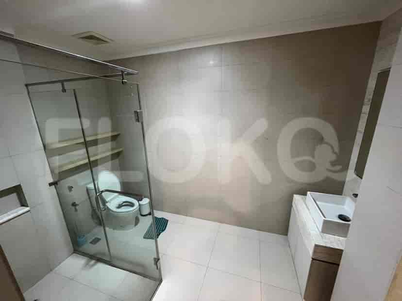 A modern bathroom featuring a glass shower enclosure, floating shelves, and a white sink.