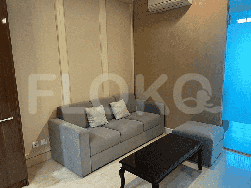 Living room with a grey sofa, ottoman, and black coffee table.