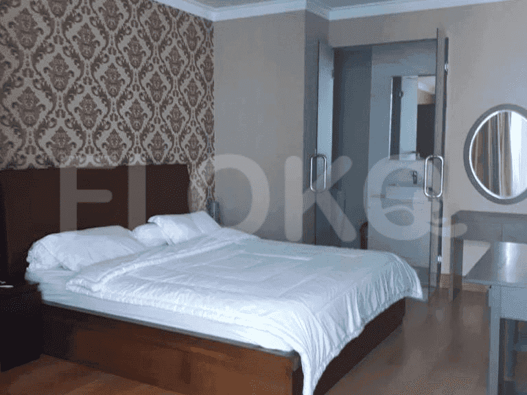 A modern bedroom featuring a large bed with white bedding and a patterned accent wall.