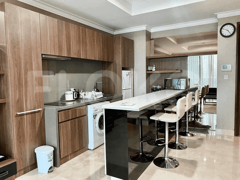 A modern kitchen with wooden cabinetry, a breakfast bar, and stainless steel appliances.