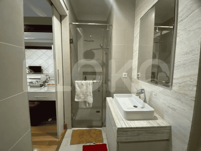 A stylish bathroom featuring a glass-enclosed shower, a modern sink, and marble accents.