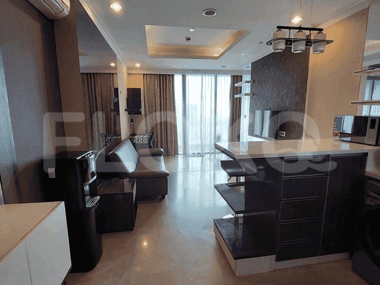 The living space and kitchen with a bar and a view of city lights.