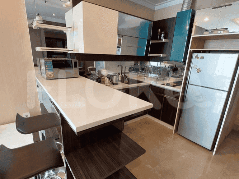 Modern kitchen with bar seating, stainless steel appliances, and white and dark cabinetry.
