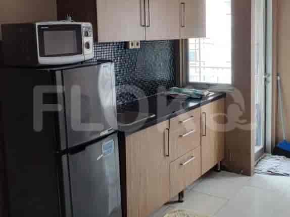 Kitchen with a refrigerator, microwave, and cabinets.