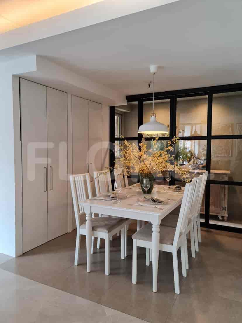 A dining room with a table, chairs, and a view of the kitchen.