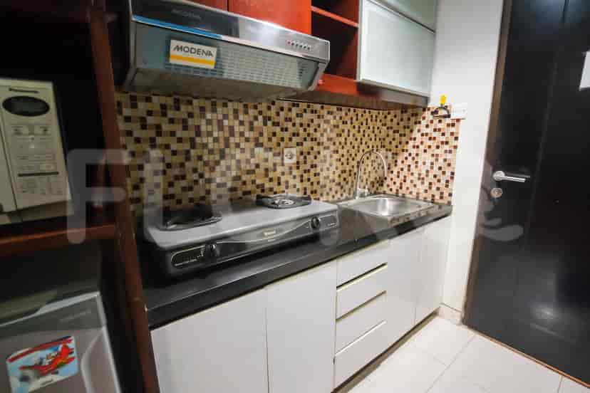 A modern kitchen with a gas stove, Modena range hood, and mosaic tile backsplash.