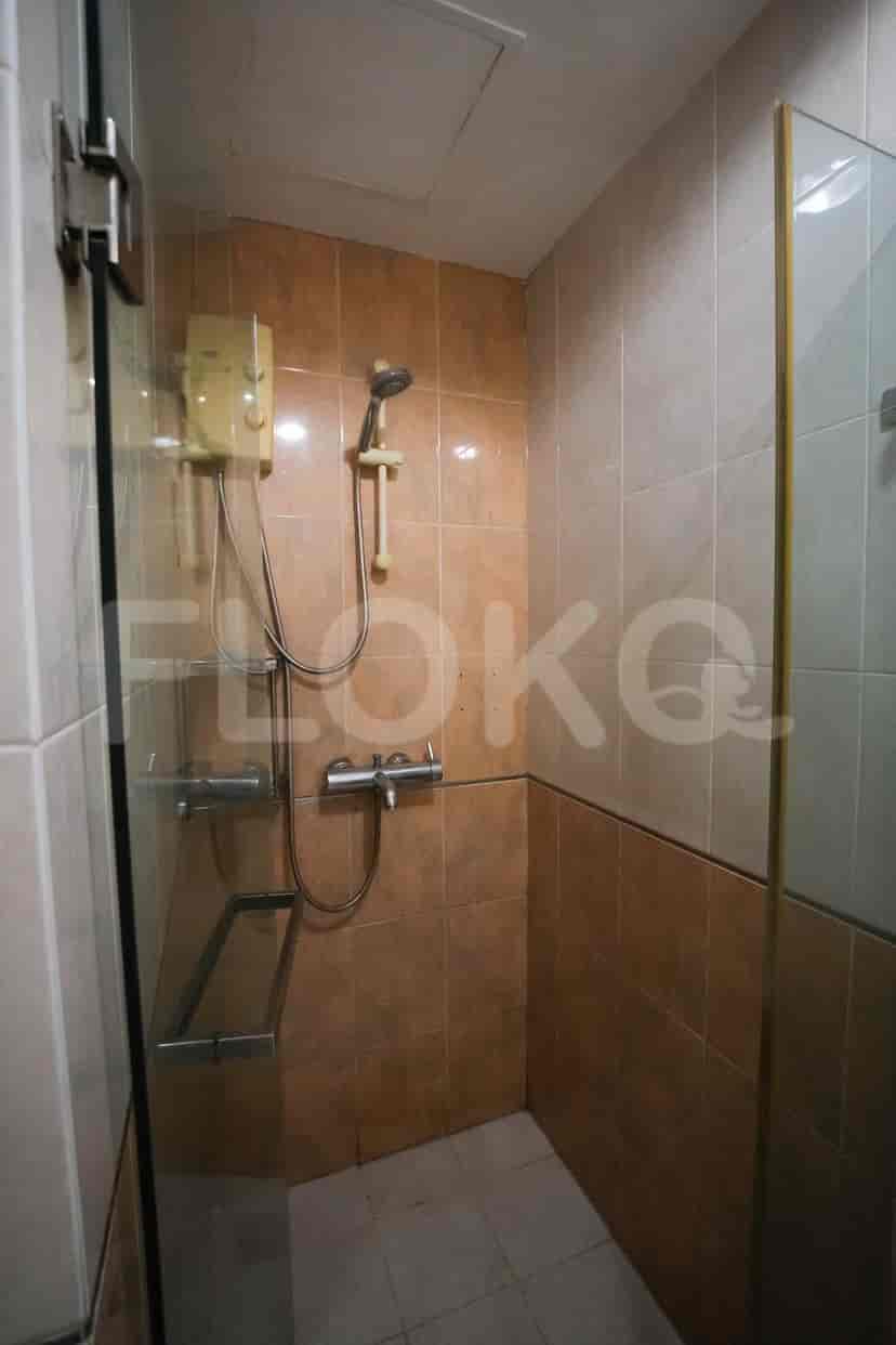 A bathroom with a shower and a tiled wall.
