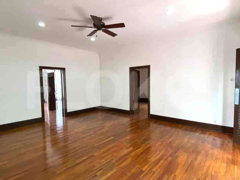 Area tamu yang luas dengan lantai kayu gelap dan beberapa pintu mengarah ke ruangan lain.