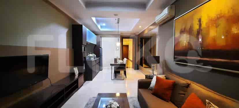 An open living space with a sofa, dining table, and kitchen area.