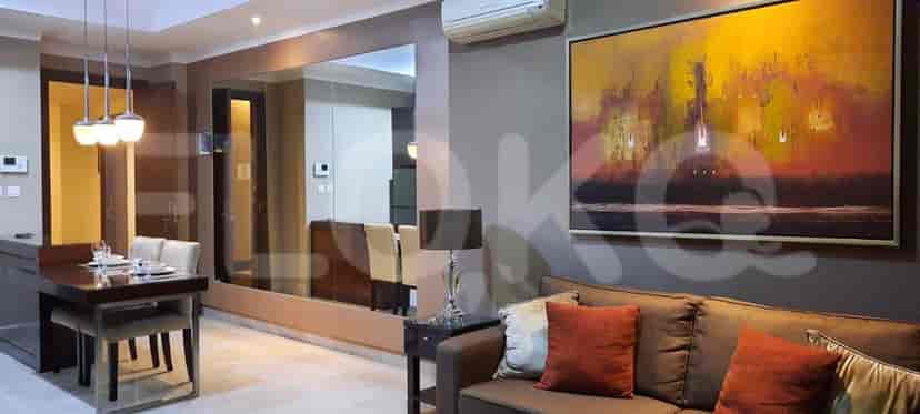 A modern living room with a sofa, dining table, and a large painting.