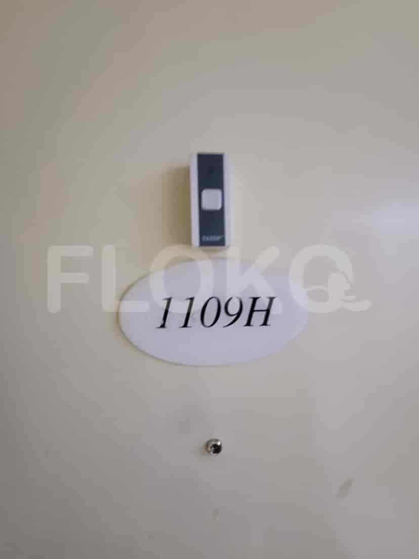 A close-up of an apartment door with a doorbell and apartment number.