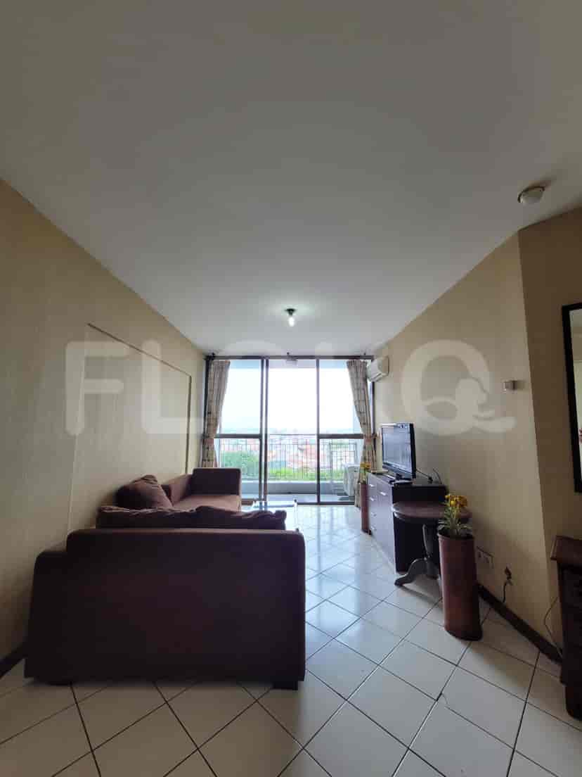 Another view of the living room with brown sofa and window overlooking the city.