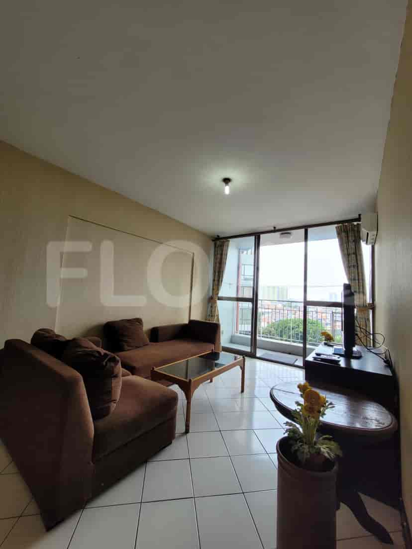 A cozy living room with brown sofa and a large window overlooking the city.