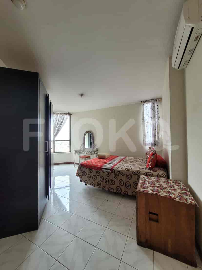 A bright bedroom with a bed, wardrobe, and vanity.