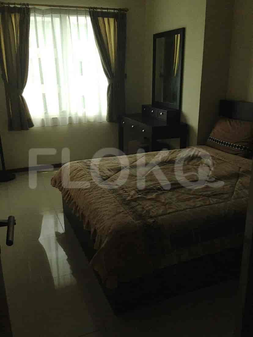 A bedroom featuring a bed, dresser and curtains.