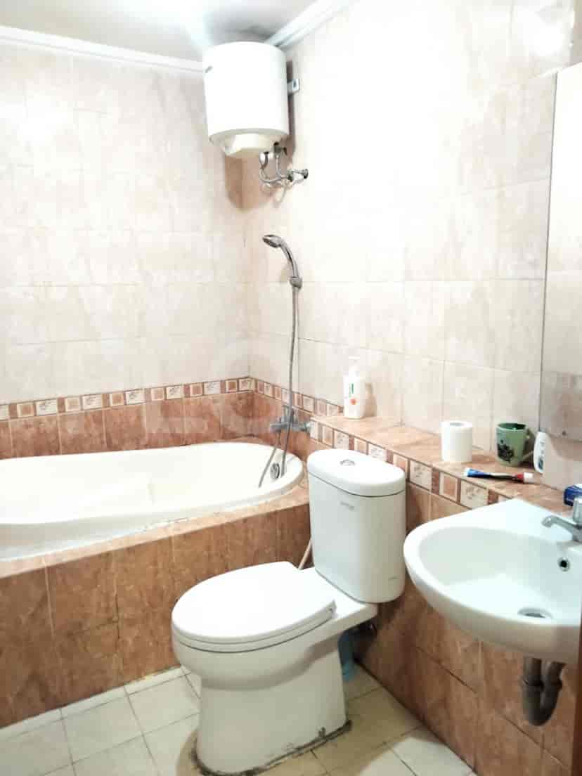 A bathroom featuring a bathtub, toilet, and sink with a large mirror.