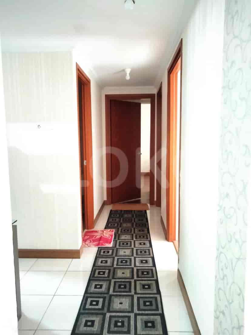 A hallway with multiple doors and a patterned runner.