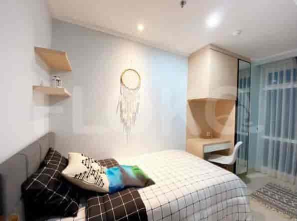 Bedroom with single bed, dream catcher and wooden furniture.