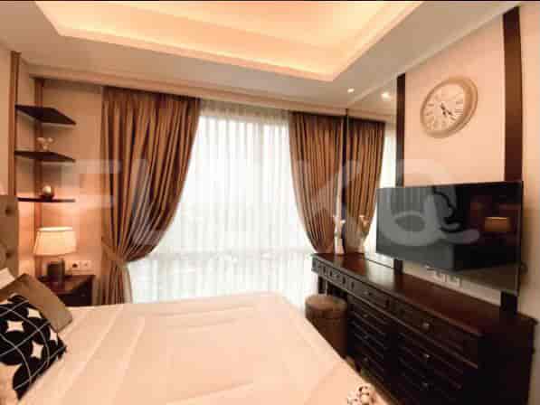 Bedroom with wooden furniture, a television, and decorative items.