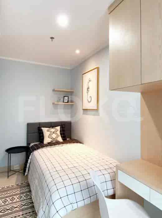 Bedroom with single bed, desk, and artwork.