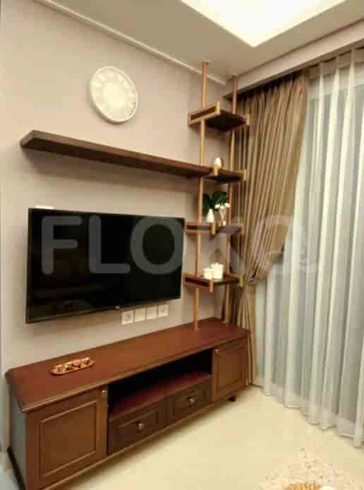 Living room with wooden furniture, TV, and decorative shelves.