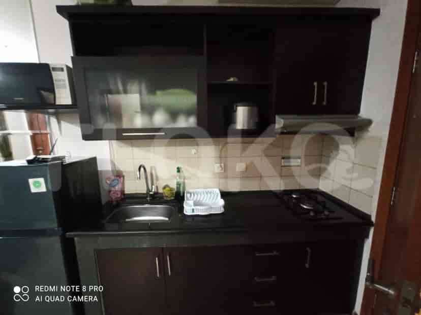 A well-equipped kitchen with dark cabinetry, a stove, sink, and refrigerator.