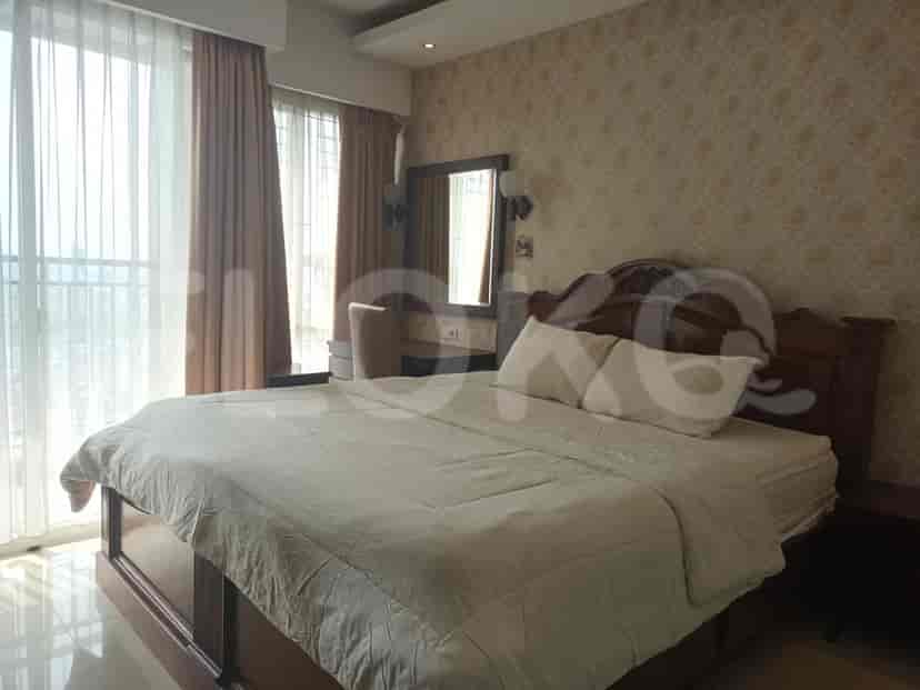 Bedroom featuring a large bed, desk, and curtains.