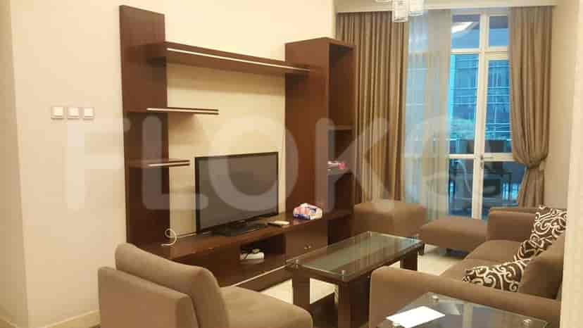 A modern living room with a TV unit, sectional sofa, and glass-topped coffee table.