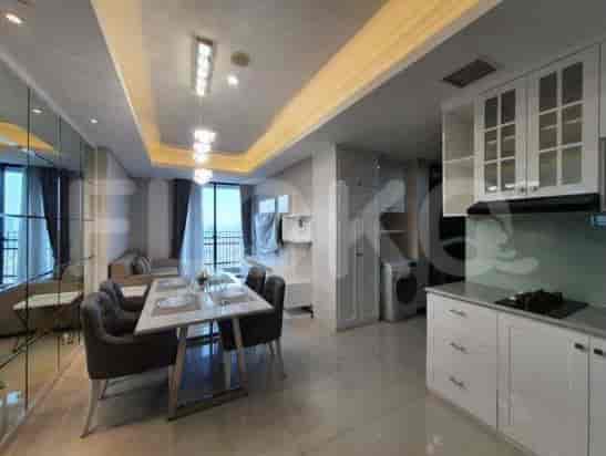 Area gabungan ruang tamu dan ruang makan dengan perabotan modern dan dapur terbuka.