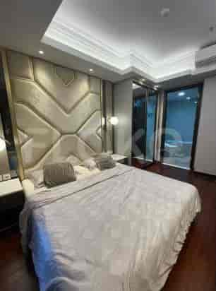 A modern bedroom with a bed, headboard, and an entrance to a bathroom.