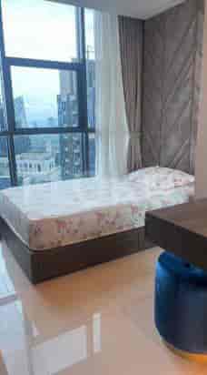 A bright bedroom with a single bed and a large window with city views.