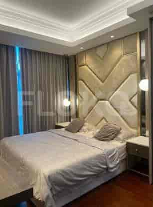A bedroom with a large bed, bedside tables, and decorative headboard.