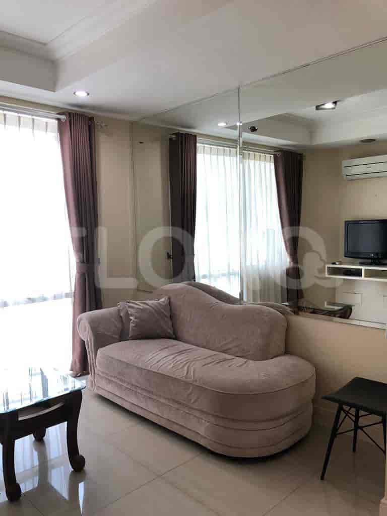 Living room with a chaise lounge, side table, and curtains.