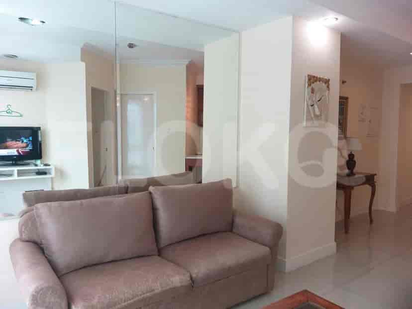 Living room with a sofa, coffee table, and access to the kitchen and a dining area.