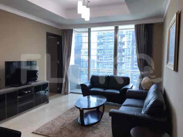 Modern living room with black leather sofa, large windows, and a contemporary coffee table.