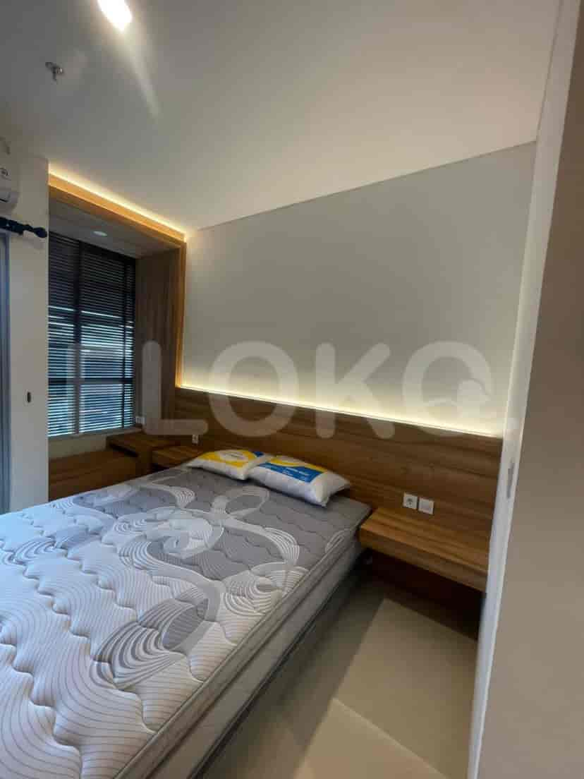 Another view of the bedroom with a double bed and wooden headboard with integrated lighting.