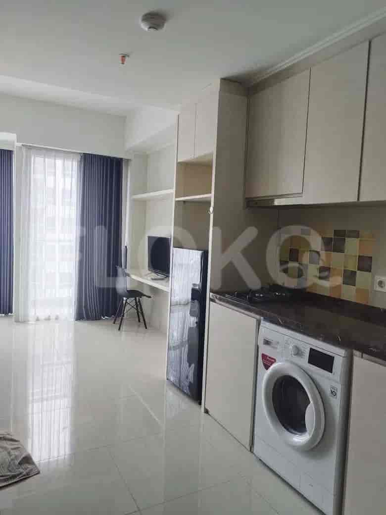 Compact living space with a combined kitchenette featuring a washer, alongside a workspace and a view.