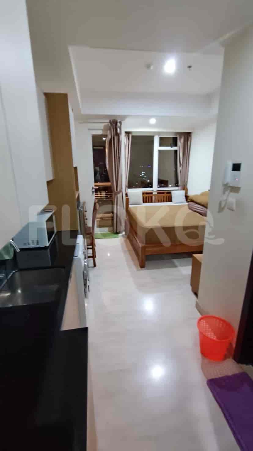 Pemandangan interior apartemen, termasuk koridor, area dapur, dan sekilas kamar tidur.