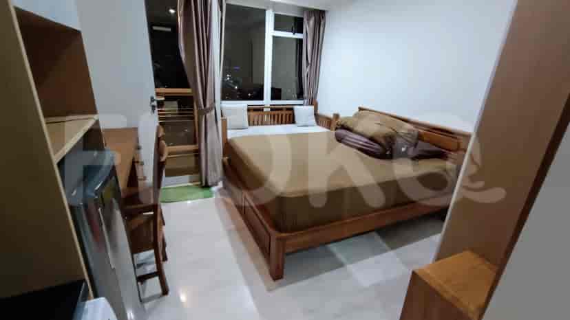 Kamar tidur yang nyaman dengan rangka tempat tidur kayu, gorden, dan akses balkon.