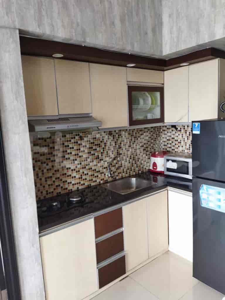 Dapur modern dengan lemari, kompor, dan lemari es.