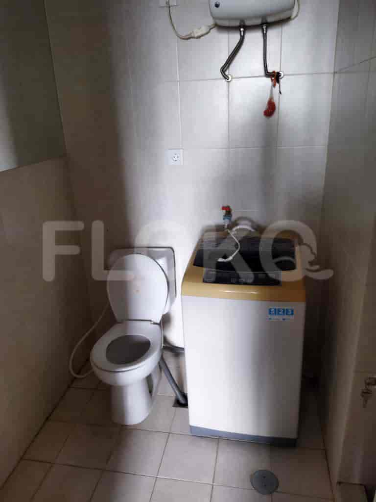 Kamar mandi dengan toilet, mesin cuci, dan wastafel.