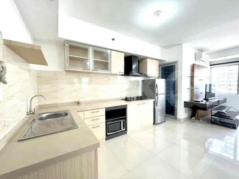 Another view of the kitchen showing the sink, microwave, and more of the cabinetry.