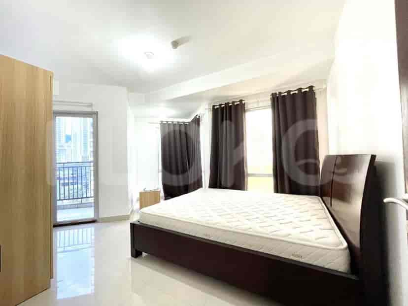 A bedroom with a large bed, wardrobe, and access to a balcony.