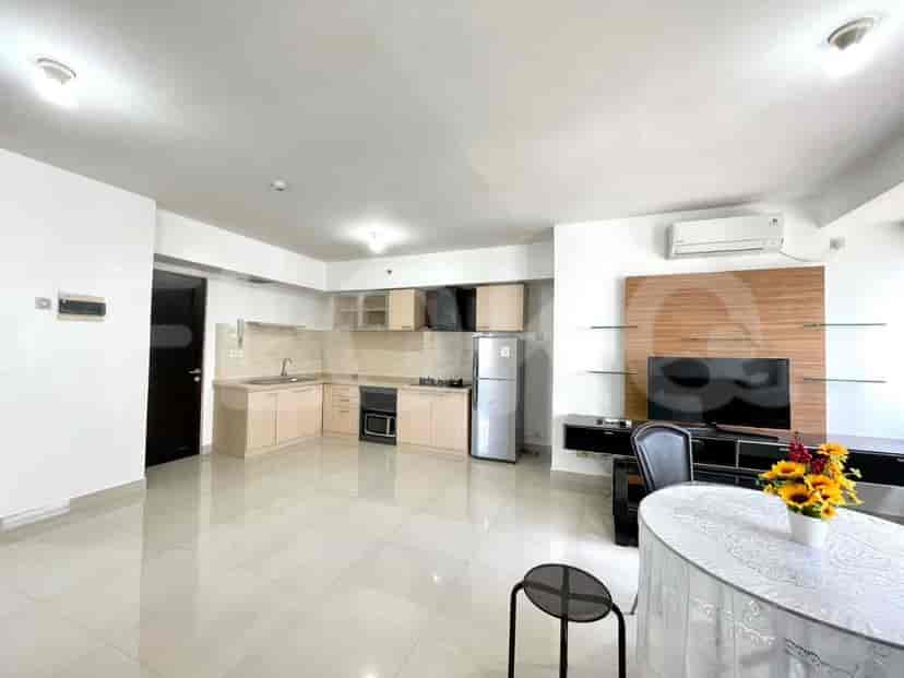 A bright kitchen with light-colored cabinets, a stainless steel refrigerator, and a tile backsplash.