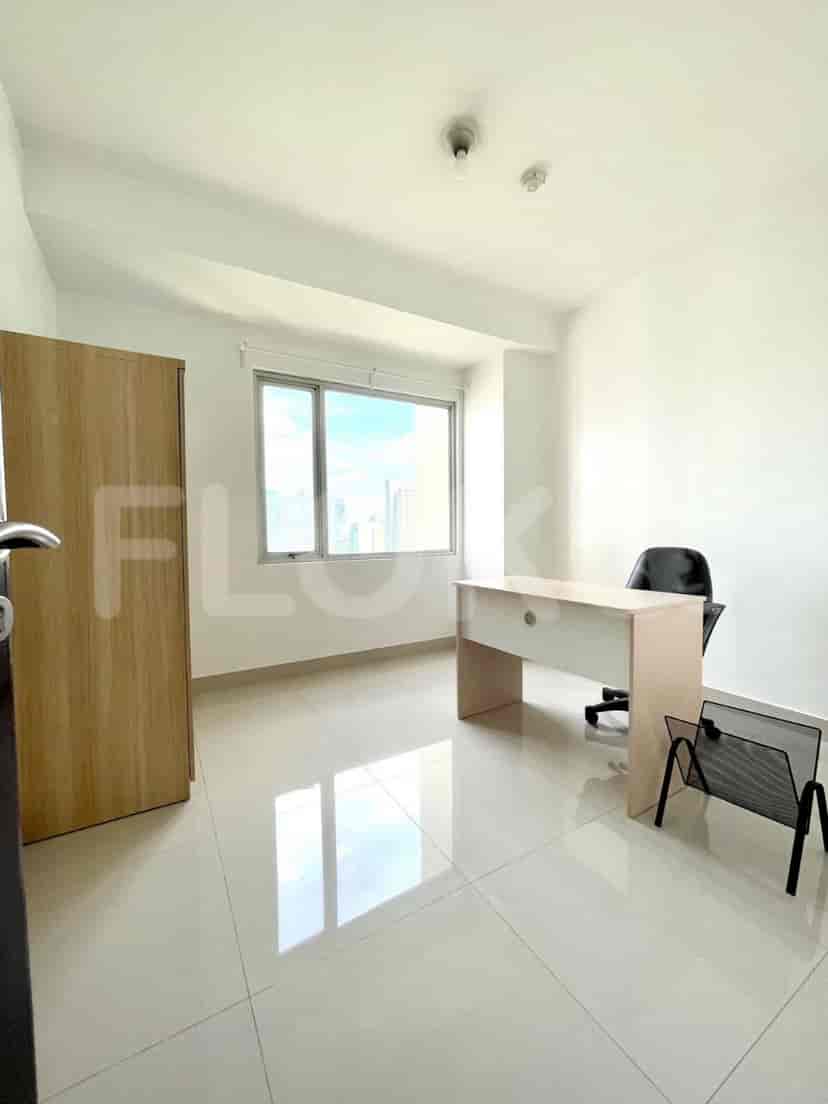 A small home office space with a desk, chair, and a large window.