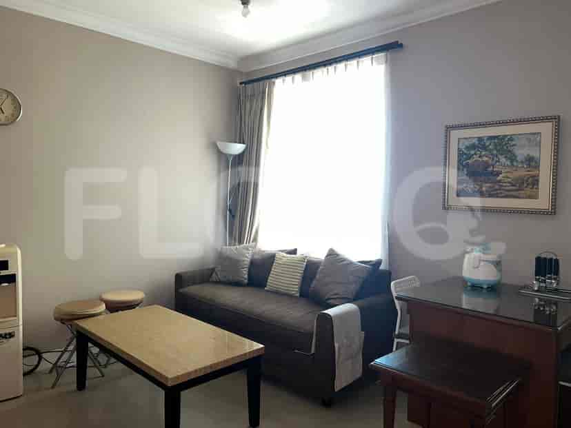 A living room with a sofa, coffee table, and a window.
